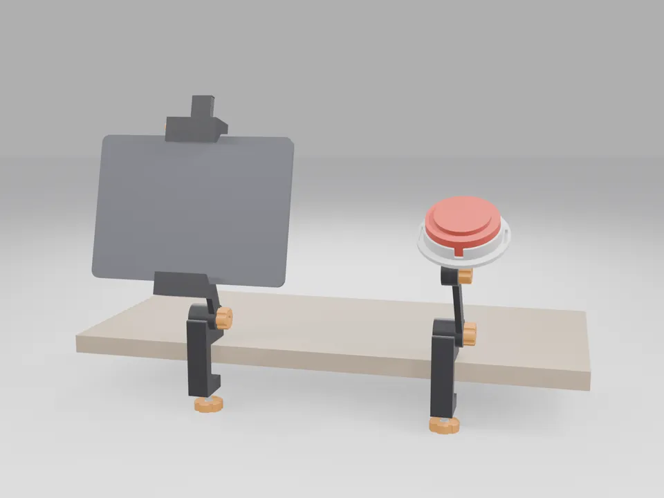 A black tablet mount clamped to the edge of a plain desk holding a grey tablet-sized slab in landscape, and a switch mount on a second clamp holding a red round switch-shaped stand-in in a white cup