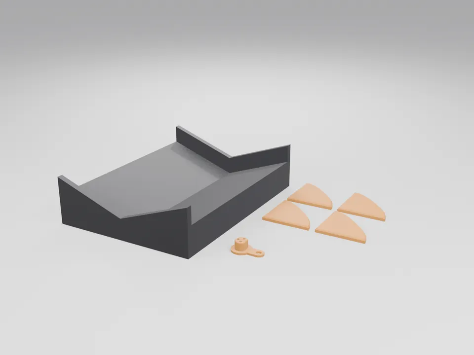 Black 3D printed V-shaped tyre cradle stand with side cheeks, four small orange chamfered corner guards and an orange D-shaped plug with a pull tab