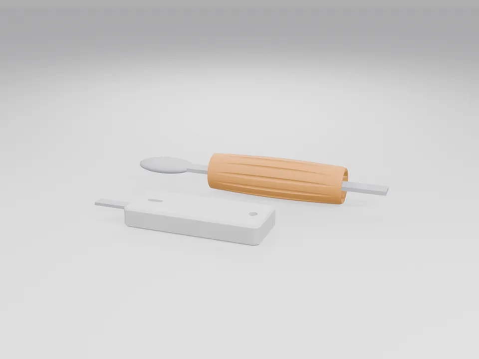 The orange sleeve fitted over the handle of a plain generic spoon shape, and the white key turner holding a plain generic flat key, on a flat surface