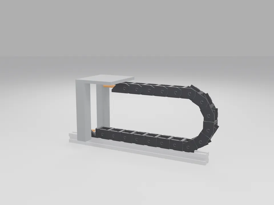 The black chain mounted between a grey 2020 extrusion bar and a plain carriage block above it, carrying a loop of cable through the bend