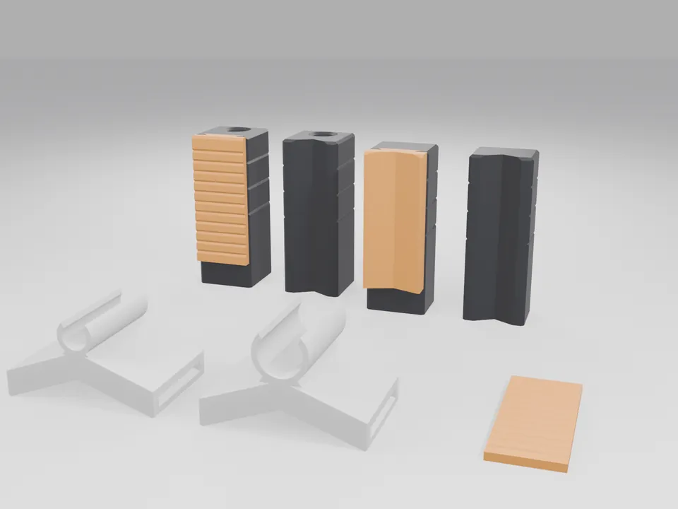 Four black 3D printed robot gripper finger blanks standing in a row, two with orange rubber-like grip pads (one ribbed, one V-shaped), two with a V-groove, plus two white cable guide clips and an orange ribbed stick-on pad