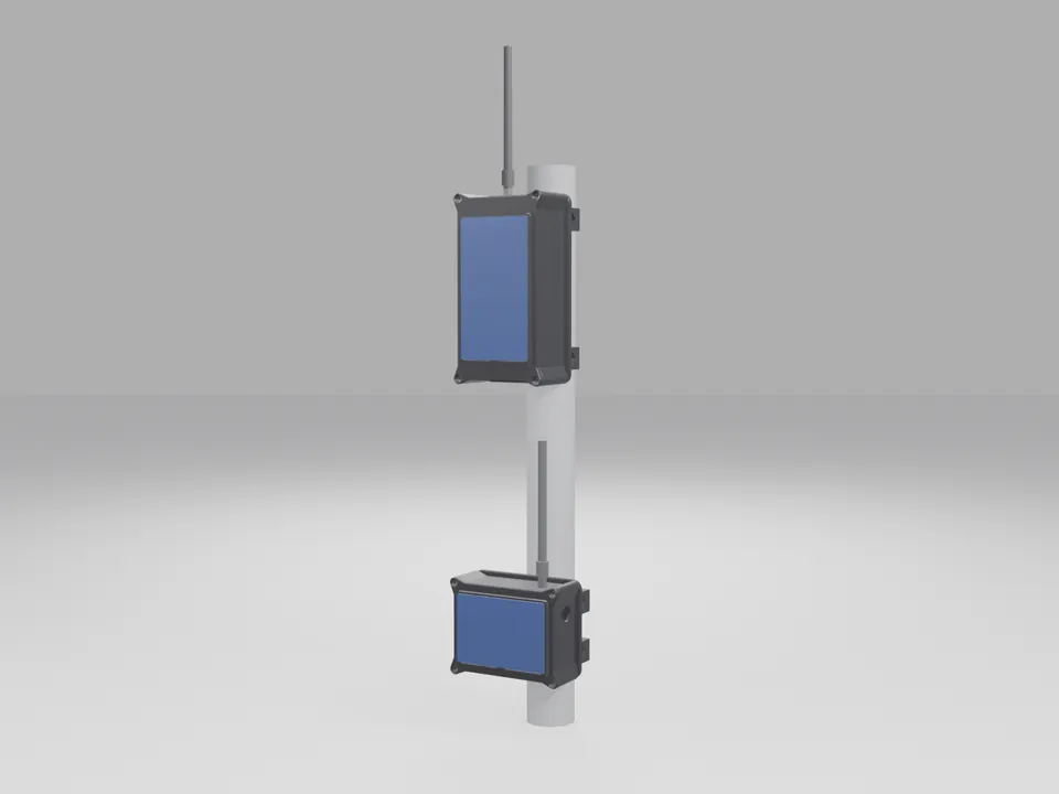 Two black node cases with blue solar panels on their lids clamped to a grey pole by black brackets, each with a grey antenna pointing up