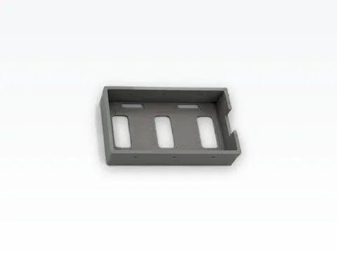 Grey 3D printed low-CG battery tray for a 1/24 crawler: a shallow open pocket with rectangular strap slots in its floor