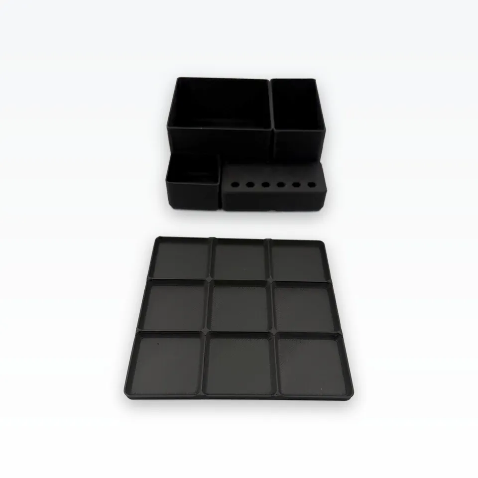 Black 3D printed 3x3 baseplate with nine square pockets next to the assembled bins