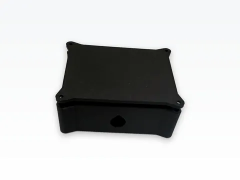 Front view of a black 3D printed LoRa mesh node case with its lid on, showing the teardrop-shaped port hole in the side wall