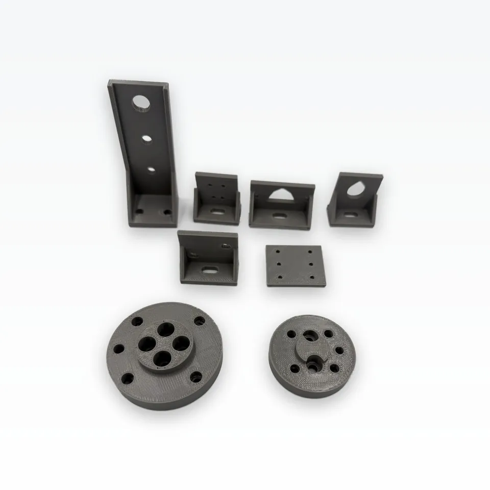 Grey 3D printed robotics parts seen at an angle: tall suction-cup arm, four sensor brackets, a flat coupon plate and two round flange adapters