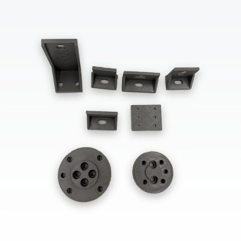 Front view of grey 3D printed sensor brackets, a suction-cup arm, a KW12 coupon and two flange adapters showing their counterbored holes